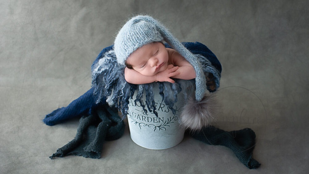 sleepy baby boy in blue knits and layers studio portrait newborn photographer sussex Samphire Photography