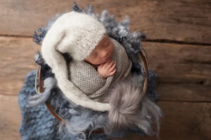 baby twins photographer Sussex newborn boy asleep blue grey knits wraps layers bobble hat studio portrait Samphire Photography