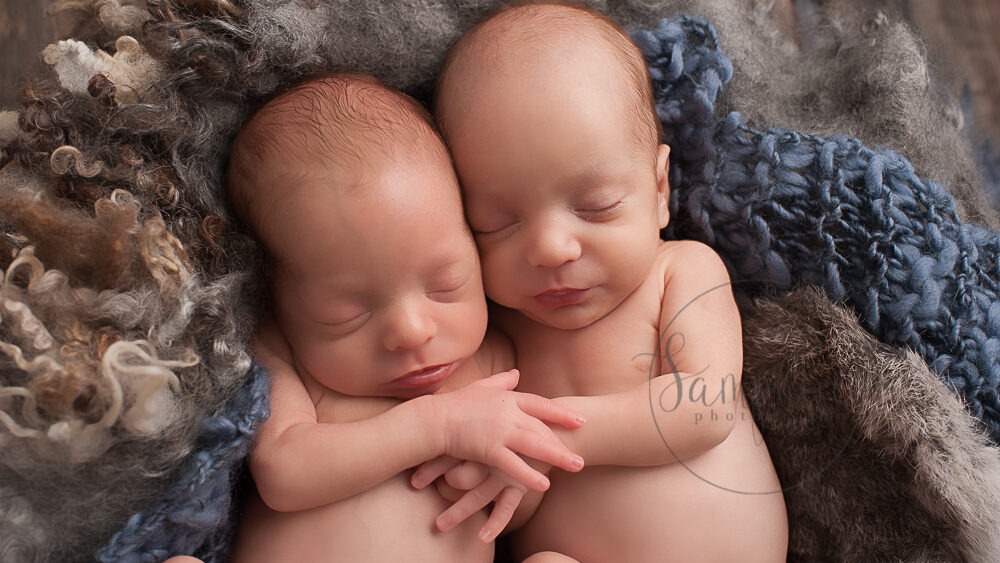 baby twins photographer Sussex blue grey layers holding hands asleep knits studio portrait Samphire Photography