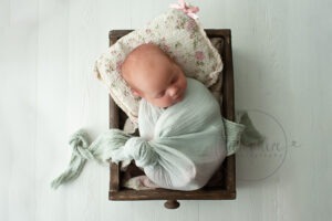 newborn baby photographs Sussex mint green warp pink floral pillow studio portraits by Samphire Photography