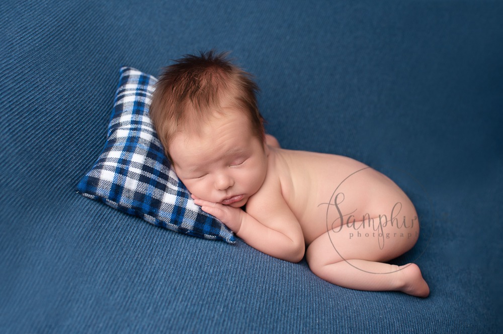 Experienced newborn photographer West Sussex sleeping baby boy blue tartan pillow studio portrait Samphire Photography