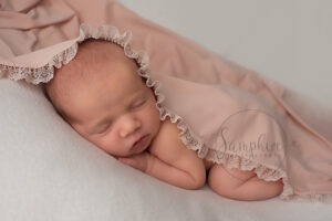Professional Newborn Photographer Sussex takeing sleeping baby girl's portrait
