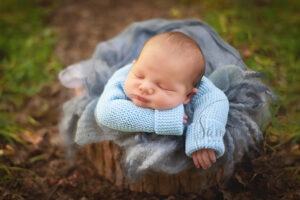 Woodland Maternity and Newborn Session baby boy sleeping outdoors blue knitted cardigan Samphire Photography