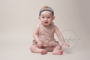 Baby's first year milestone portraits pink floral patterned romper headband Samphire Photography Sussex