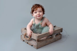 happy baby in crate taken by baby photographer horsham