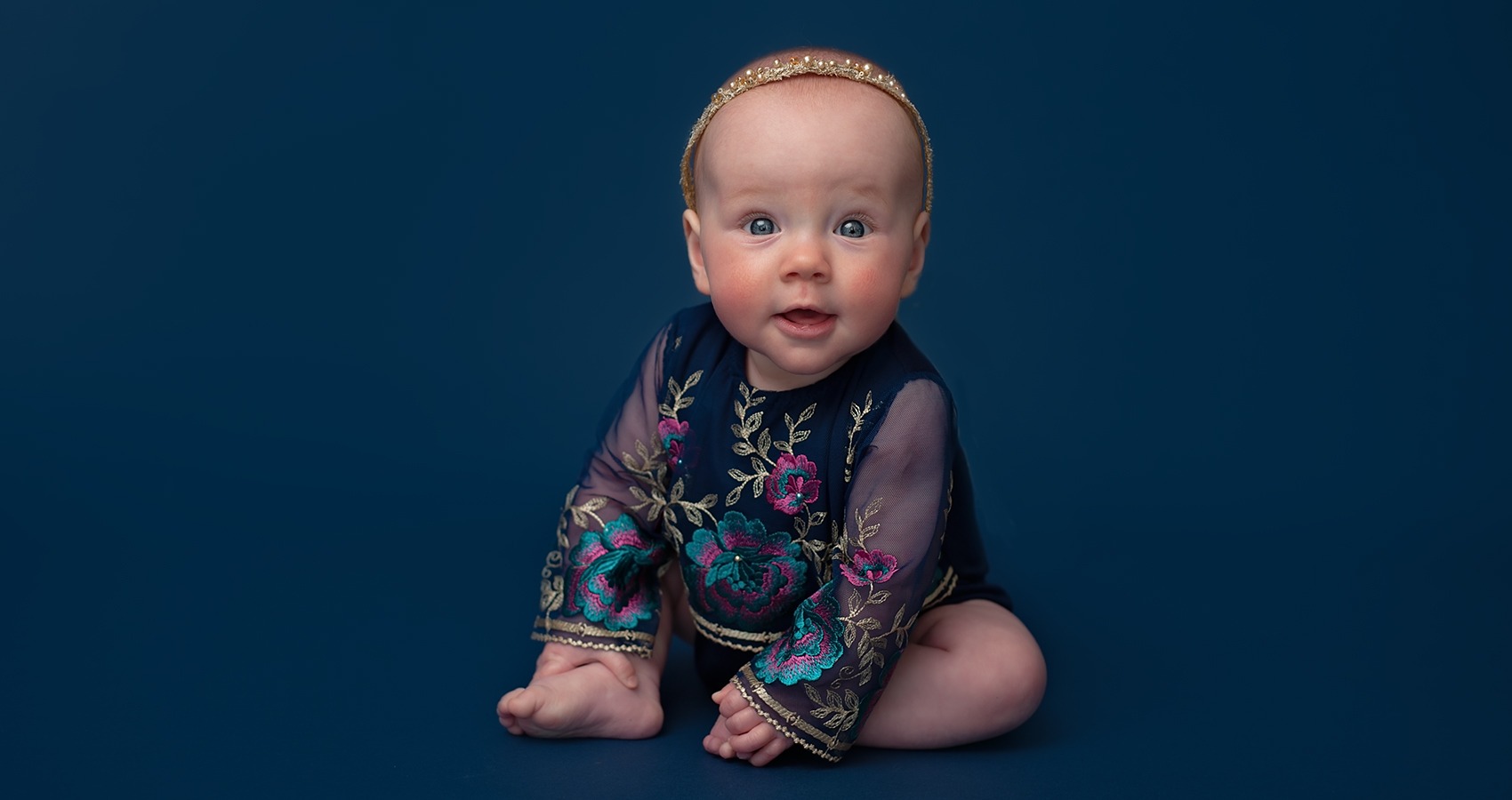 Milestone Baby Portrait and baby photo shoots happy little girl in blue by Horsham Photographer Sussex