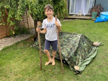 boy in front of camo tent