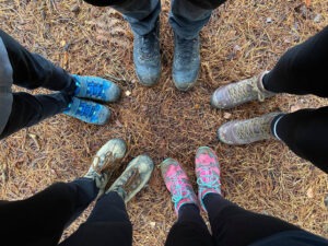 five pairs of feet wearing walking boots