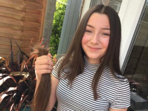 smiling teenage girl holding bunch of hair