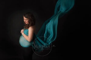 pregnant woman with green fabric studio portrait