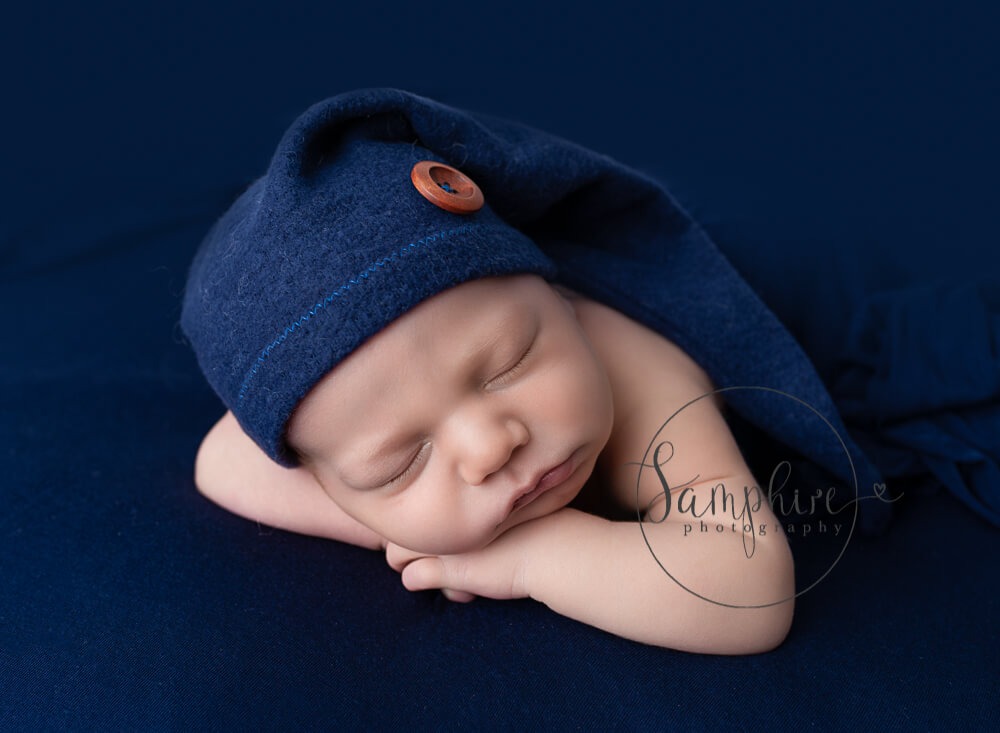 Chbosing a newborn photographer with a little boy on a blue blanket in West Sussex