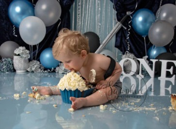 boy licking cake at his majestic themed cake smash by Samphire