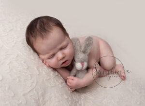 baby girl cuddling rabbit prop in west sussex