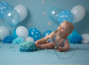 little boy in blue with blue cake