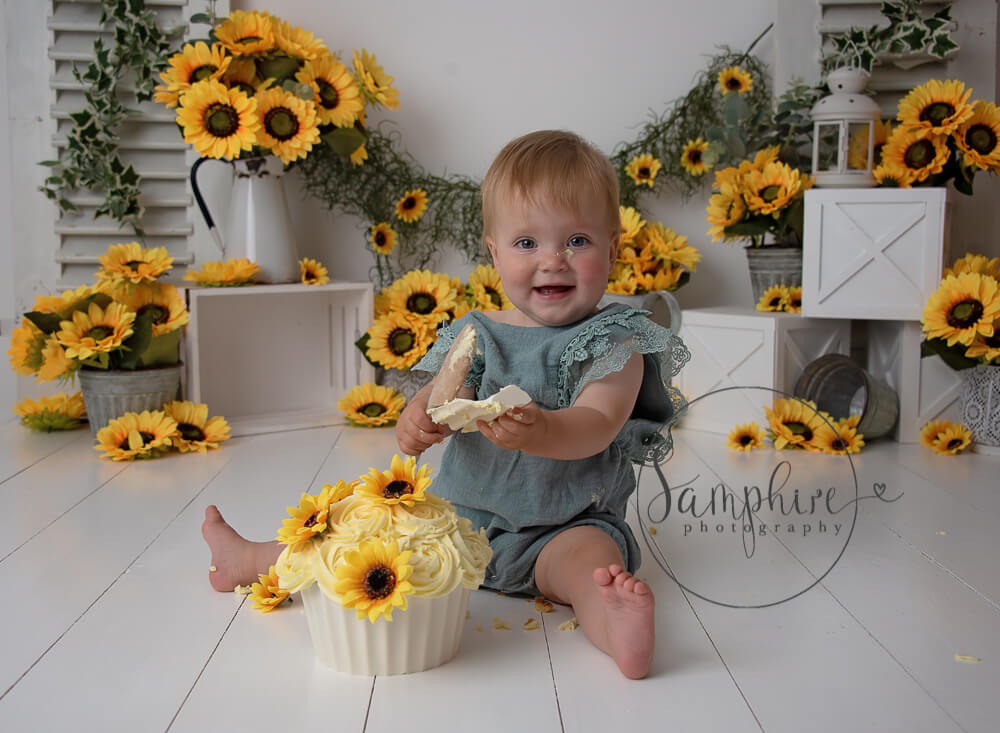 happy girl enjoying a sunflower cake smash