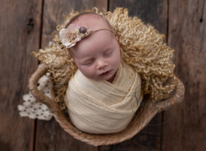 Little girl in yellow wicker basket choosing a newborn photographer
