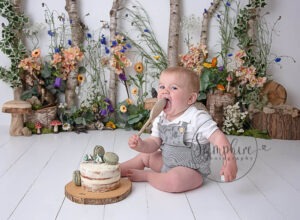beautiful floral woodland cake smash styled for first birthday boy
