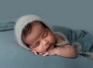 baby boy asleep wearing grey knitted hat
