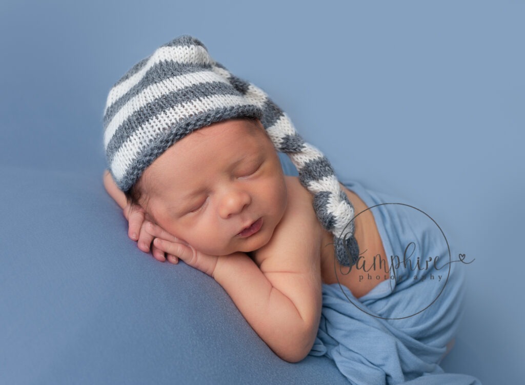 baby boy asleep wearing striped knitted hat