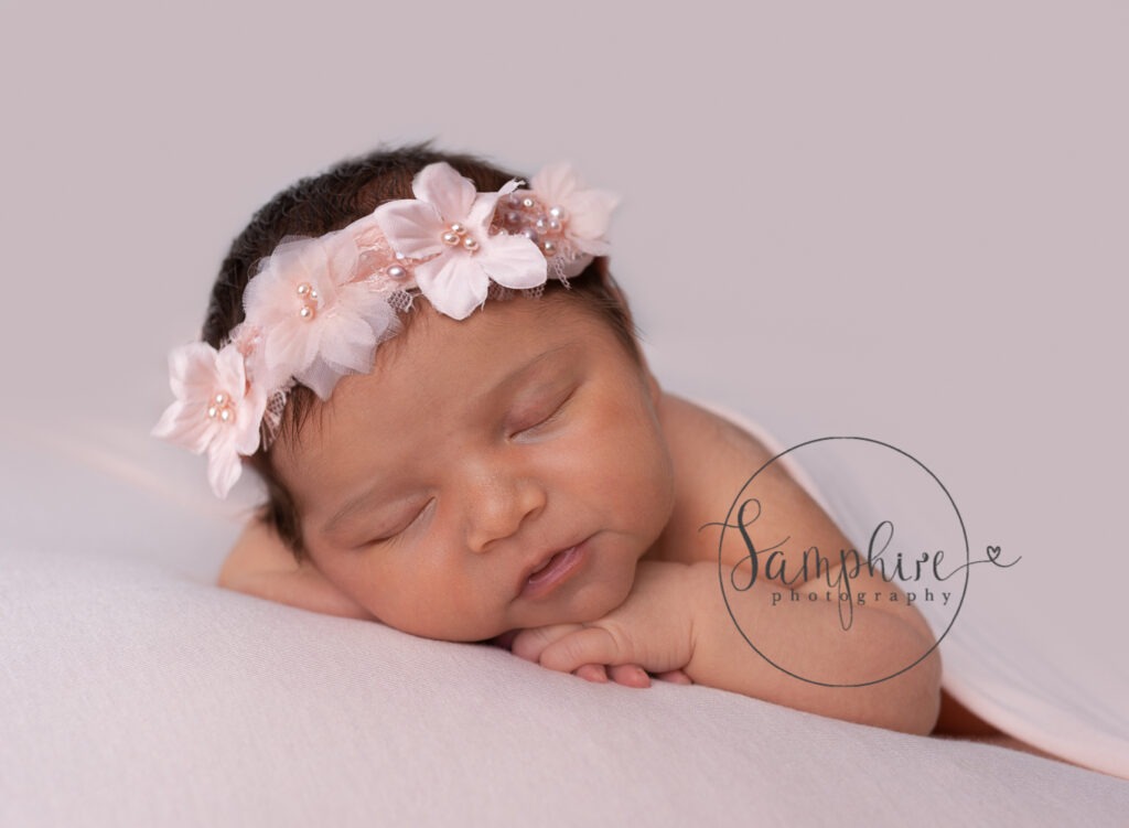 baby girl asleep wearing pretty pink floral headband