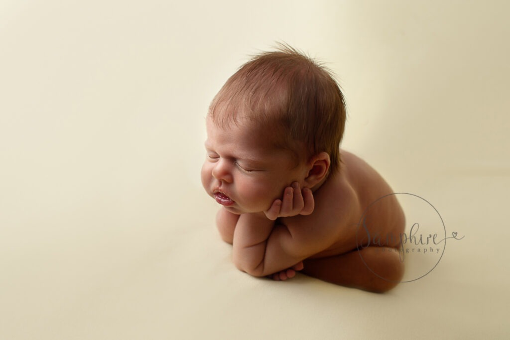 baby in froggy pose at his behind the scenes at a newborn session