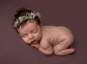 sleeping rainbow baby girl wearing flower crown