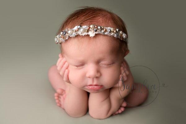 newborn girl with head on hands composite photo