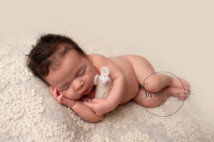 newborn baby cuddling toy mouse