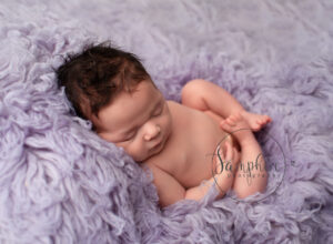 newborn asleep on lilac flokati