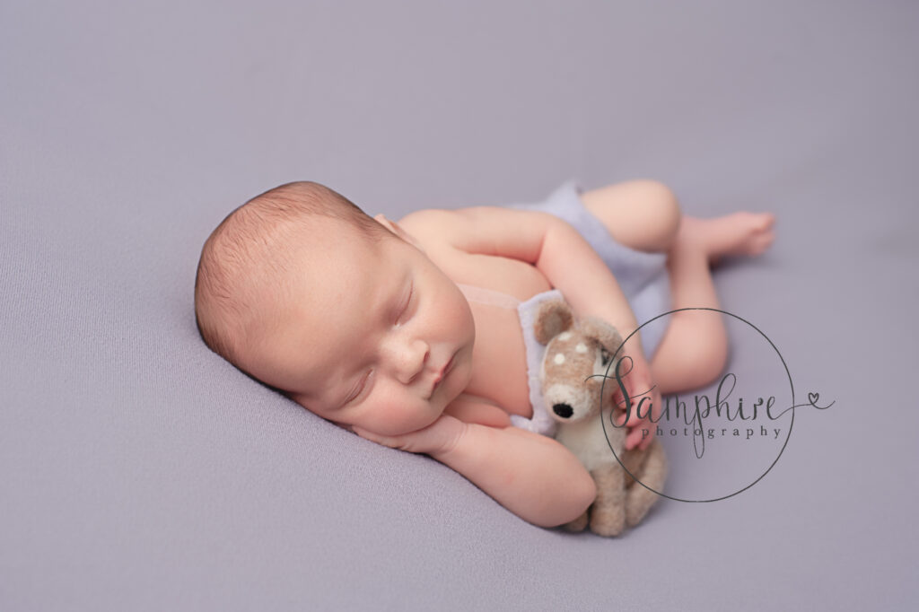 sleeping newborn baby with felted fawn
