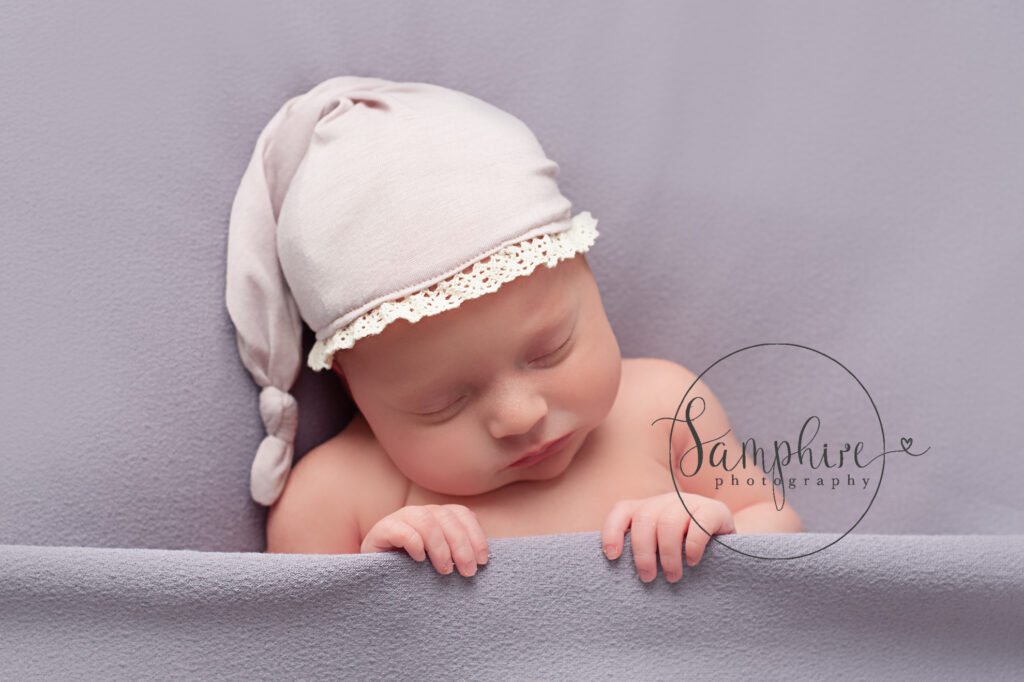 newborn asleep wearing nightcap